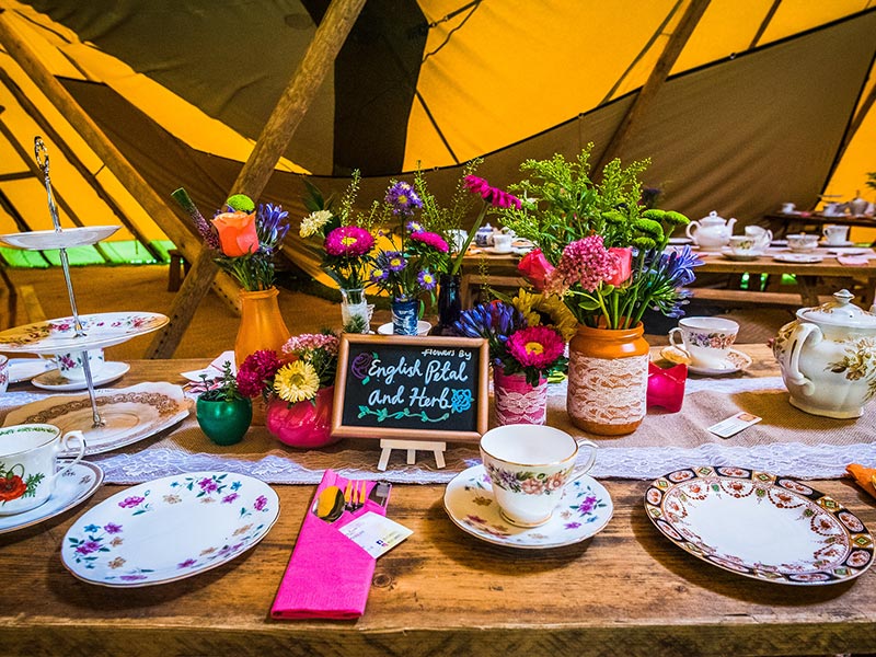 Floorplan for 1 tipi diameter of 10.3 metres, 9 sets of tables around a firepit in the centre.